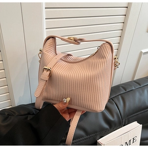 Vue détaillée du sac à main rose plissé avec texture verticale et finitions dorées
