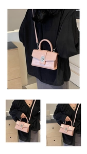 Detail of pink croc-embossed small crossbody bag with silver twist lock and top handle