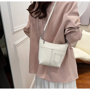 Detail der minimalistischen cremefarbenen Beuteltasche mit Ziernaht und Tasche