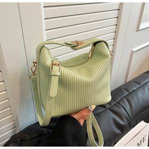 Détail d'un sac bandoulière plissé vert menthe avec ferrures dorées et bandoulière en cuir