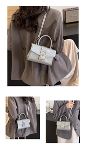 Close-up of silver crocodile embossed mini handbag with elegant metallic oval twist lock