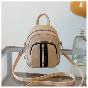 Detailansicht des beigen Mini-Rucksacks aus Leder mit modischen Quasten-Details