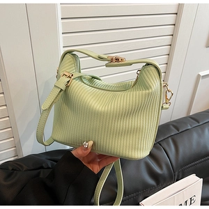 Détail du sac plissé vert menthe avec boucle en métal doré et texture en cuir