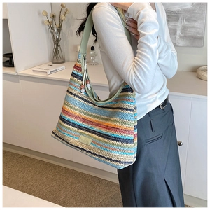 Detail of colorful woven tote bag with leather strap and wooden bead zipper puller