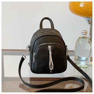 Detail eines schwarzen Mini-Rucksacks aus genarbtem Leder mit Doppel-Reißverschluss und Silber-Hardware