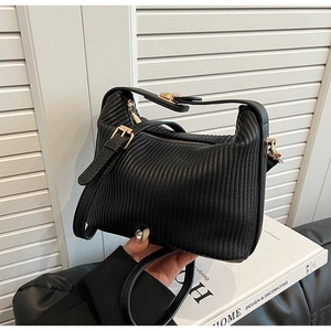 Détail du sac à main noir plissé avec fermeture éclair dorée et finitions métalliques