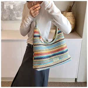 Detail of colorful striped woven hobo bag with a zipper charm and brand label
