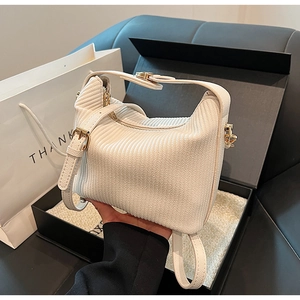 Détails d'un sac à main en velours côtelé blanc avec rayures et boucles dorées