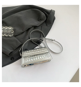Detail of silver crocodile pattern texture on a high-gloss fashion shoulder handbag