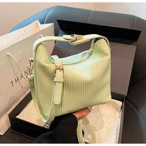 Détails d'un sac à main plissé vert clair avec des finitions dorées et une fermeture éclair