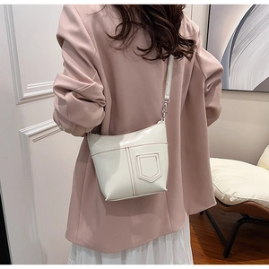 Detailansicht der stylischen weißen Umhängetasche mit Nahtdetails an einem Model