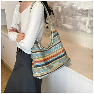 Detailed macro view of colorful striped woven tote bag with beaded charm and logo tag