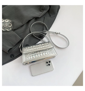 Detail of silver metallic handbag with crocodile embossed texture and sleek square structure