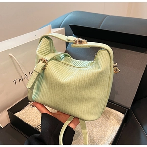 Détail du sac à main plissé vert clair avec boucle dorée et bandoulière réglable