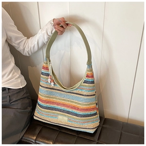 Close-up of rainbow woven tote bag featuring colorful stripes and beaded tassel charm