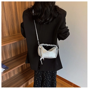 Détail du sac à main plissé argenté avec texture métal liquide et bandoulière