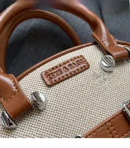 Macro detail of canvas fabric, brown leather trim and ZSKE logo on the crossbody bag