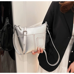 Nahaufnahme einer silbernen Metallic-Schultertasche mit Vordertasche und feinen Nähten