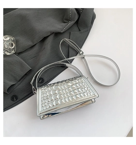 Detailed close-up of a silver metallic crossbody bag with geometric embossed texture