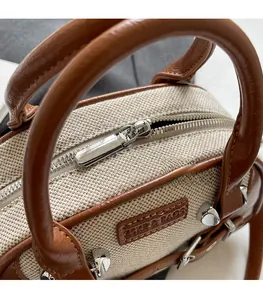 Close-up of contrast canvas and leather stitch with silver zipper on retro Boston bag