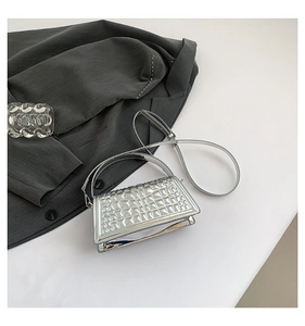 Close-up of silver crossbody bag featuring a textured 3D square embossed metallic finish