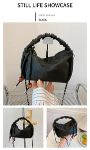 Détail du sac en cuir embossé noir avec poignée plissée et cordon à perles d'ambre