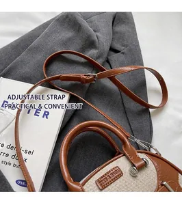 Detail of two-tone brown leather and canvas crossbody bag with adjustable strap