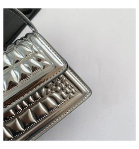 Close-up of metallic silver handbag with unique 3D embossed geometric grid texture