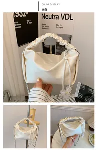 Détail du sac à main plissé blanc cassé avec perles transparentes et bandoulière chaîne