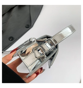 Detail shot of the glossy silver metallic tote with a structured handle and sleek finish