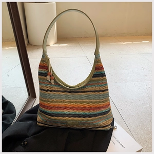 Detail of colorful striped woven tote bag with wooden bead pendant and small brand tag