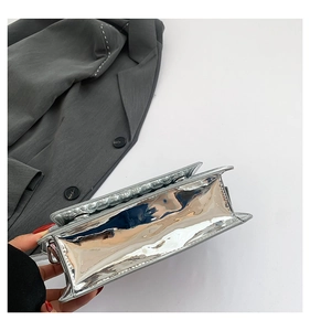 Side view of silver glossy faux leather handbag with sleek metallic finish