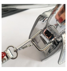 Detail of glossy silver handbag showing heavy metal D-rings and high-shine lobster clasp