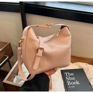 Détail du sac à bandoulière plissé rose pêche avec texture verticale et finitions dorées