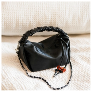Détails du sac plissé noir avec fermeture à cordon, perles d'ambre et chaîne en métal