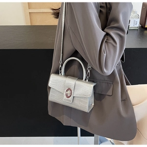 Silver crocodile texture handbag featuring a metallic turn-lock and detachable strap