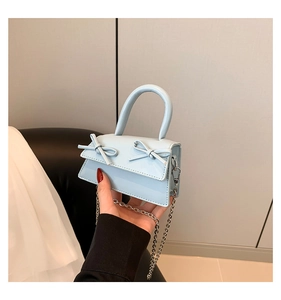 Detail of light blue mini bag with bow decoration and detachable metal chain strap