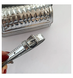 Detail of adjustable silver metallic strap with buckle on quilted faux leather bag