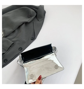 Macro view showing the silver mirror handbag interior and dual magnetic closures
