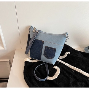 Details der blauen Denim-Patchwork-Umhängetasche mit Reißverschluss und Kontrastnaht
