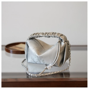 Détail du sac à main plissé argenté avec texture métallique et cordon de serrage perle
