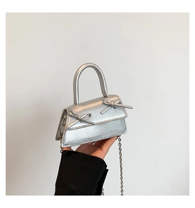 Detail of silver mini handbag with bows, metallic finish and detachable chain strap
