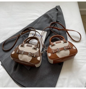 Detail of mini canvas and brown leather crossbody bags with metal buckle accents