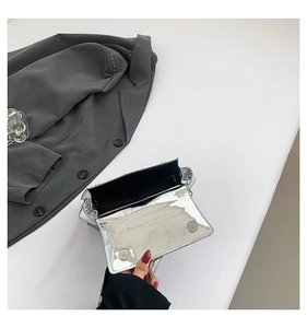 Detail of silver mirror handbags with black lining and dual magnetic snap closures