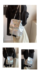 Close-up of holographic silver backpack with heart buckle and metal chain straps