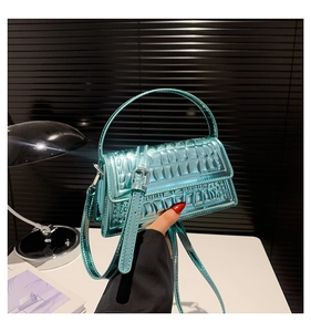 Detail of bright blue crocodile pattern handbag with silver hardware and top handle