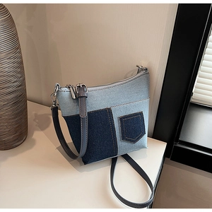 Detail der Denim-Patchwork-Umhängetasche mit blauen Einsätzen und kleiner Fronttasche