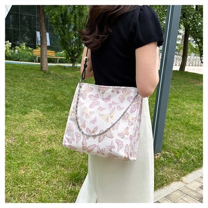 Detaillierte Stickerei von rosa-goldenen Schmetterlingsmustern auf weißer Canvas-Tasche