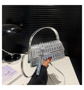 Detail of silver metallic crossbody bag with 3D quilted texture and sleek handle