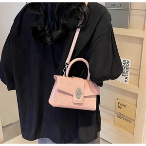 Pink crocodile pattern shoulder bag with silver metal lock shown on a model